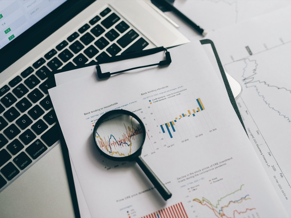 A magnifying glass over financial charts and lending data.