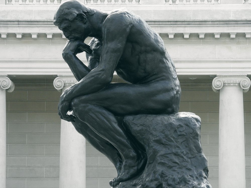 Rodin's The Thinker, a bronze statue in a contemplative pose.