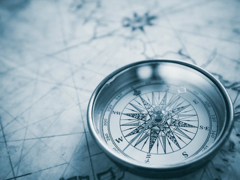 A compass resting on an old map.